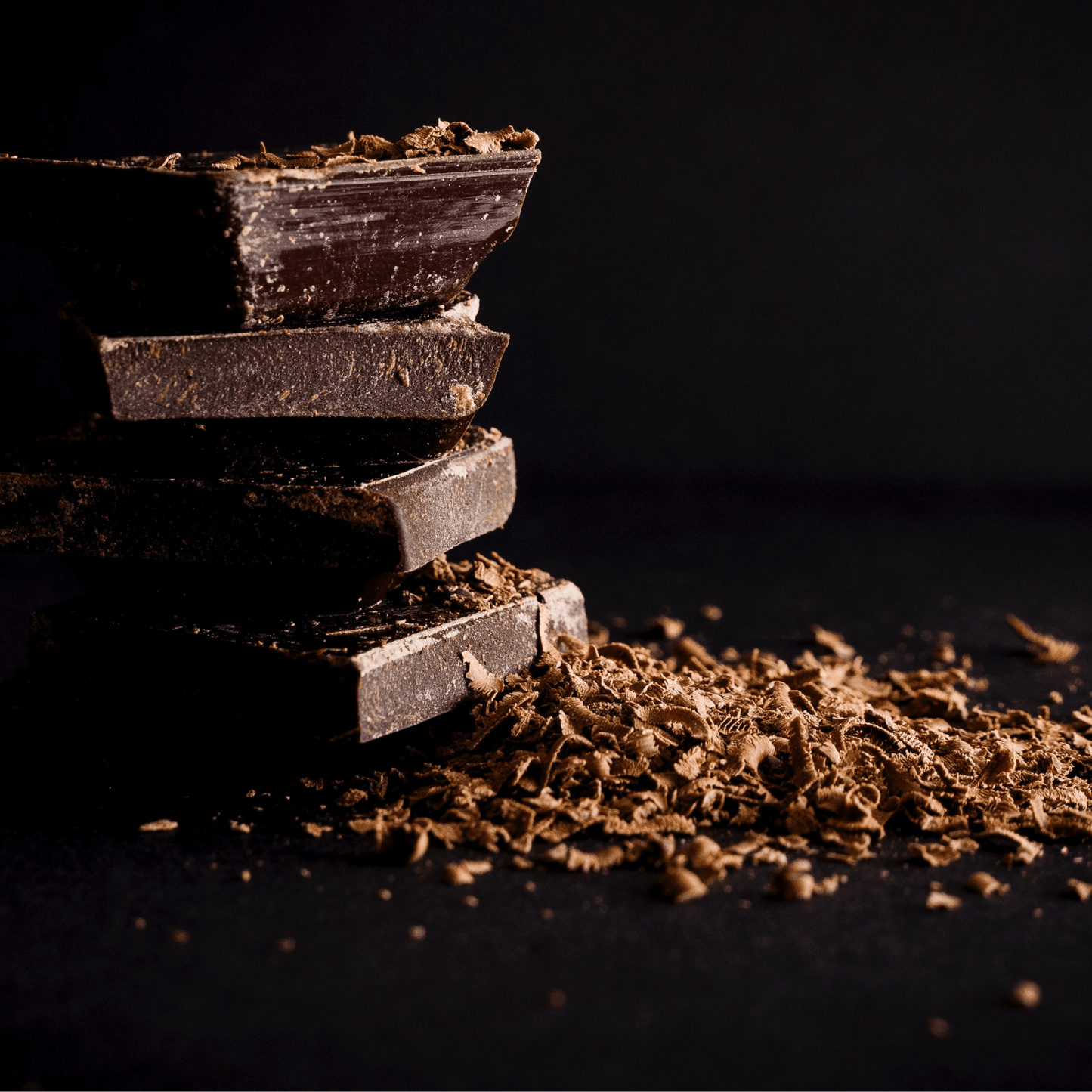 Stack of chocolate with shavings on a dark background