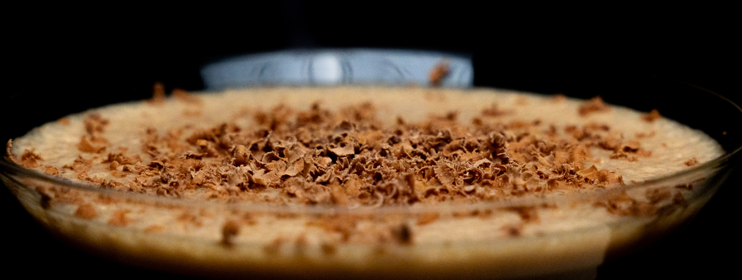 Top of mocktail with chocolate shreds on top of it on a black background