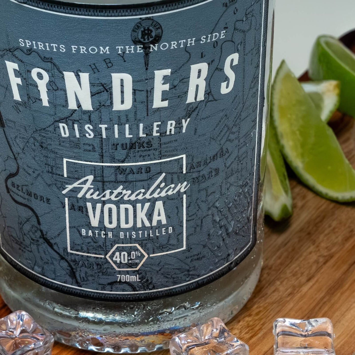Close up of Finders Distillery Vodka bottle with fresh lime on a wooden board 