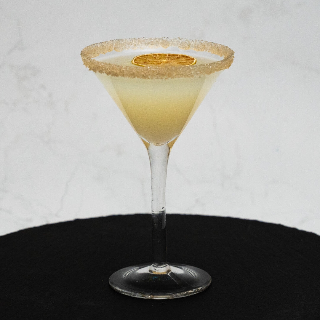 Lemon Drop Martini Cocktail in a martini glass with a sugared rim on a white background
