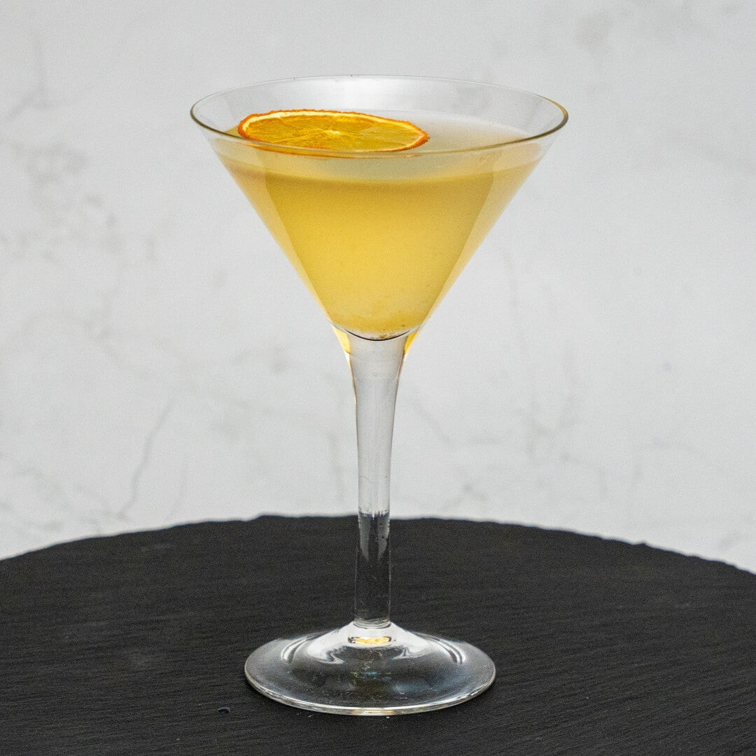 Orange Daiquiri Cocktail in a martini glass with an orange slice on a white background