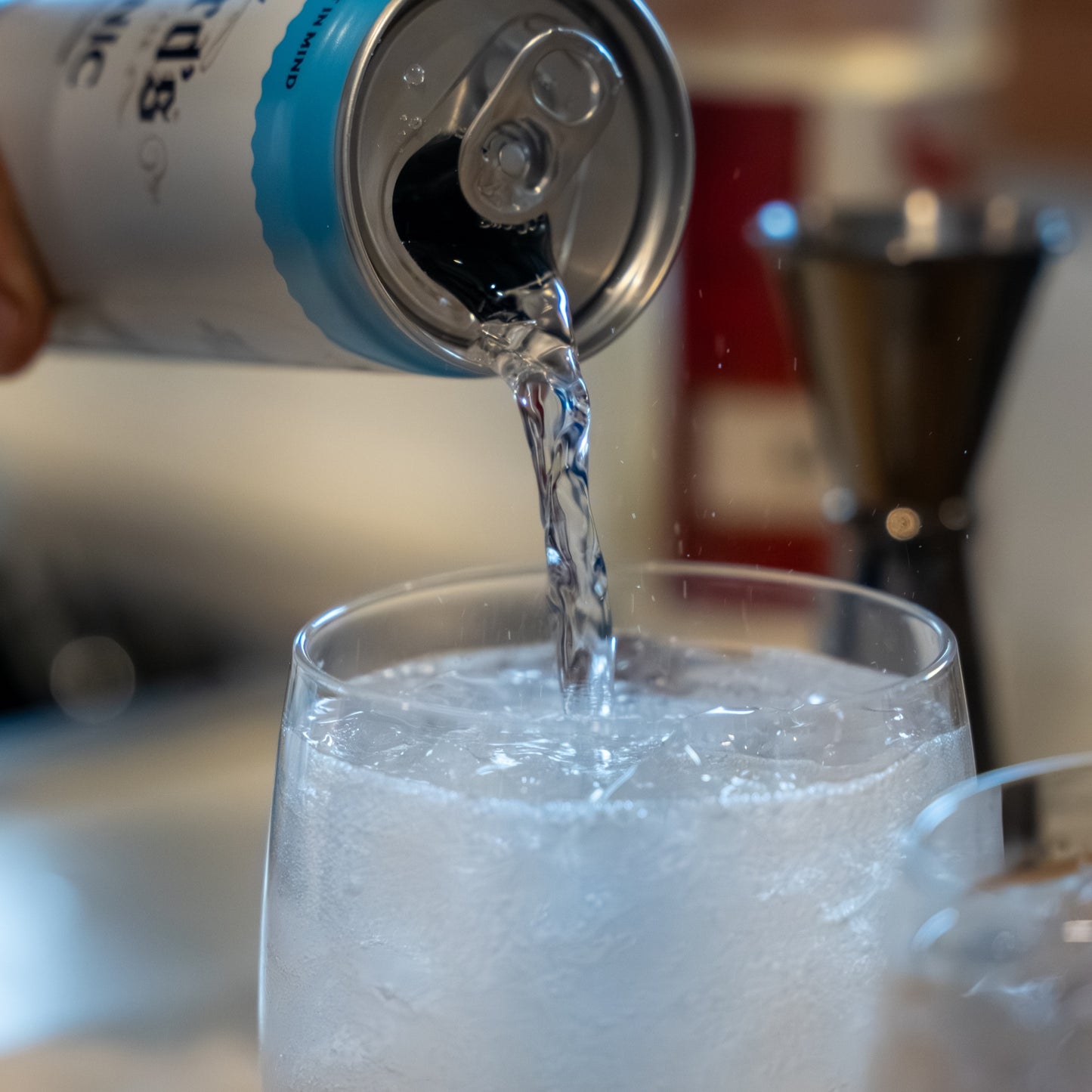person pouring a can of Bickford's Tonic Water into a short glass to make a gin and tonic