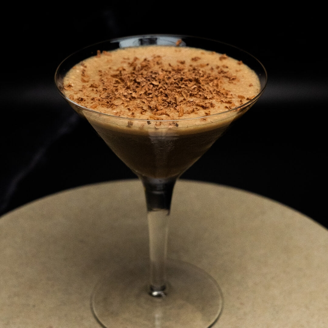 Decadent Coffee mocktail with grated chocolate garnish on a dark background