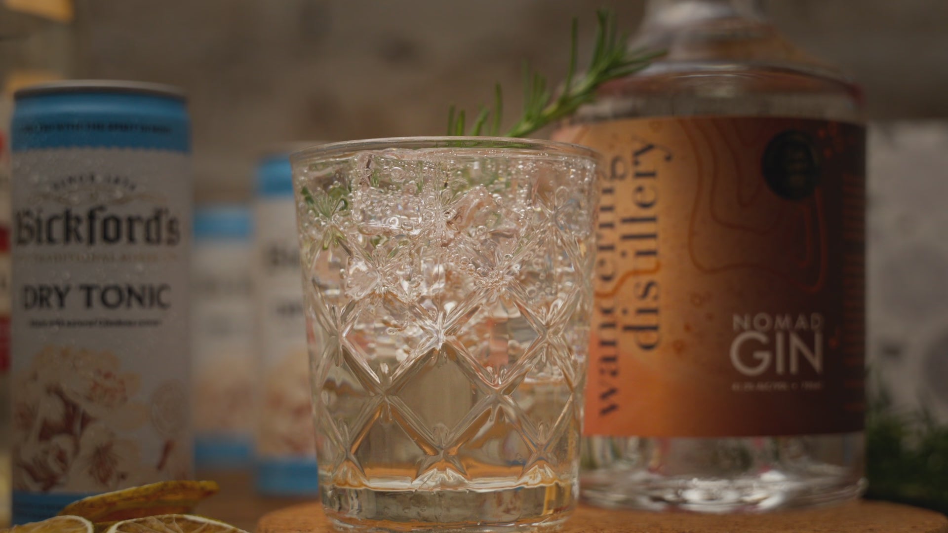Video shows elderflower gin and tonic cocktail kit close up, with dried lime garnish placed before video zooms out to show full contents of the kit. Including Wandering Distillery Nomad Gin, Bickford's Tonic Water and Red Elf Elderflower Syrup