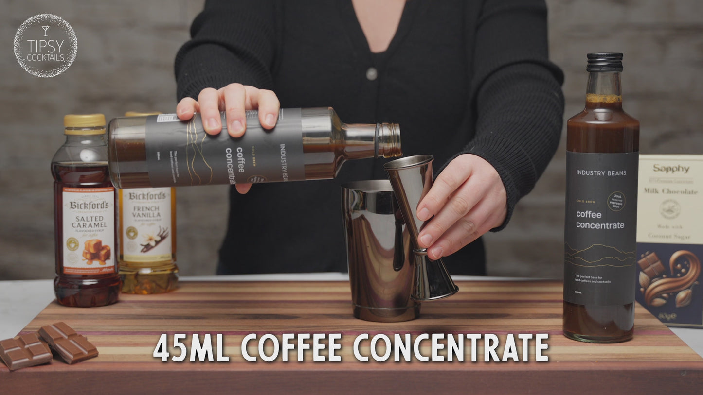 Video shows recipe of making velvet hour cocktail. Start by adding 45ml coffee concentrate to shaker, 20ml salted caramel syrup, 15ml french vanilla syrup and 60ml of milk of your choice to shaker. Fill shaker with ice, place lid on and shake shake shake. Strain all liquid and froth into martini glass. Generously grate milk chocolate onto top of mocktail for garnish. Enjoy!
