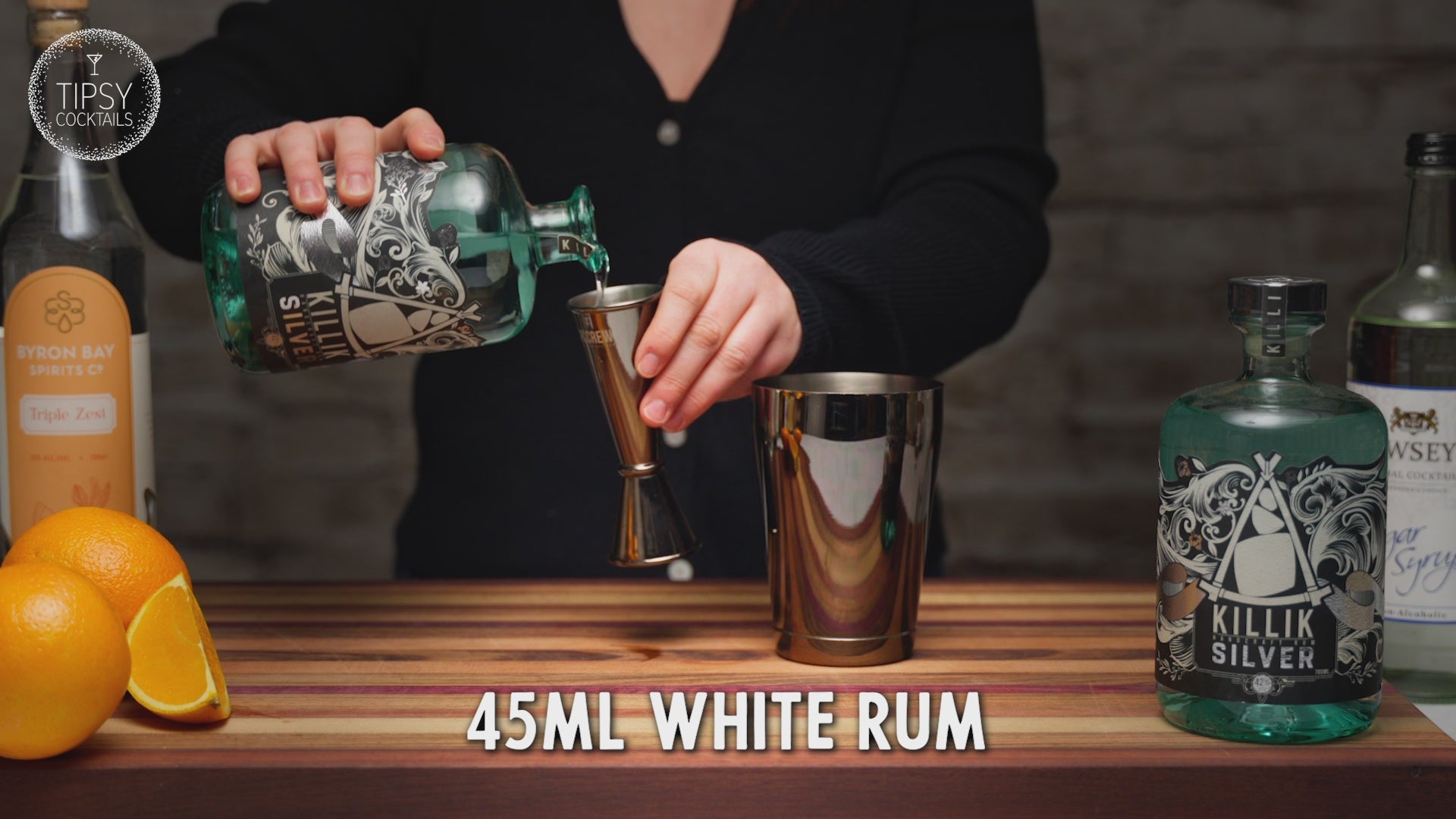 Video shows the recipe and making of a Tiki Orange Daiquiri. Start by adding 45ml of white rum into cocktail shaker, 15ml Triple Sec, 15ml sugar syrup, good squeeze of fresh orange juice. Fill shaker cup with ice and put lid on. shake, shake shake. Strain all liquid into martini glass and garnish with dried orange slice. Enjoy fresh or, enjoy frozen by adding all ingredients to a blender with 1 cup of ice. Frozen and fresh daiquiris are shown side by side at the end. 