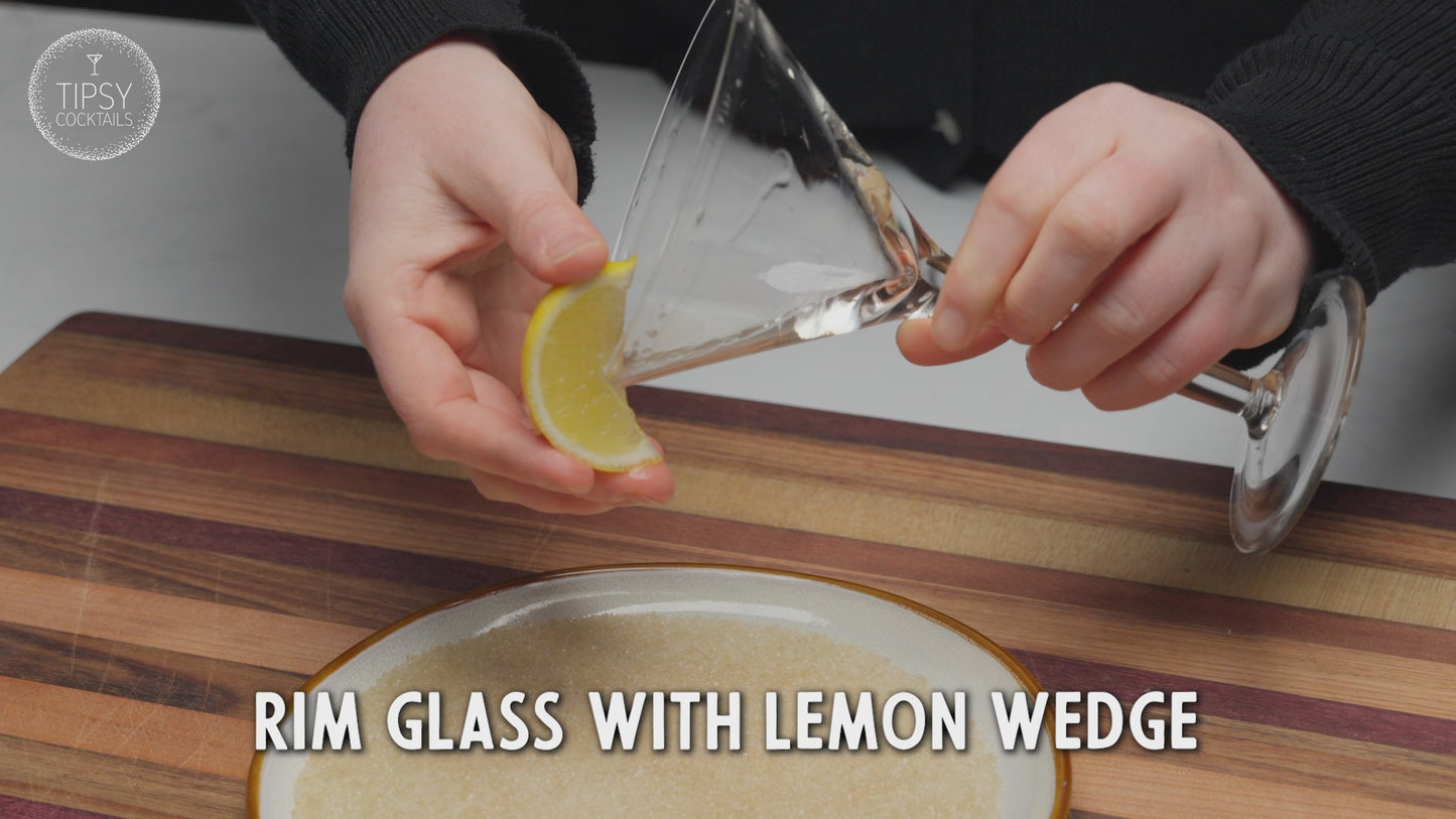 Video shows the recipe and making of a lemon drop martini. Starting with rimming a martini glass with lemon wedge and dipping glass into granulated sugar. Put glass aside and add 45ml vodka, 20ml triple sec, 10ml sugar syrup and a good squeeze of fresh lime to your shaker. Fill shaker with ice, place lid on and shake shake shake. Strain liquid into your rimmed martini glass and garnish with a dried lemon wedge. Enjoy!